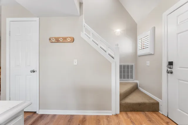 a view of a hallway with wooden floor and a living room