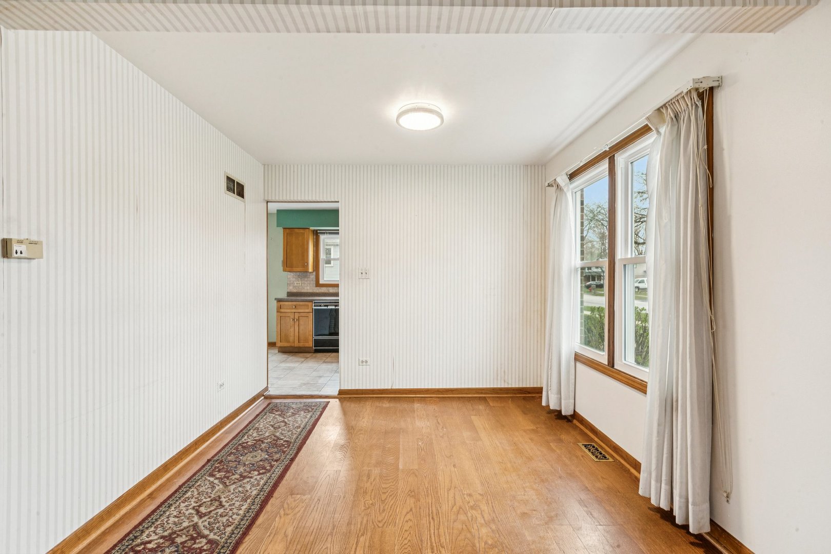 18604 Carpenter Street Homewood, IL 60430 - Photo 5 of 31 an empty room with wooden floor and windows