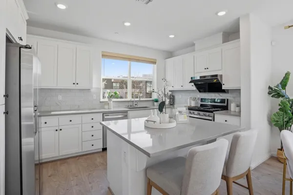 a kitchen with sink a microwave and cabinets