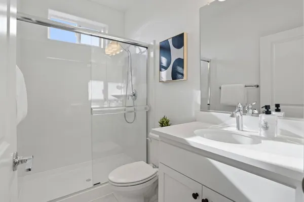 a bathroom with a granite countertop sink toilet and shower