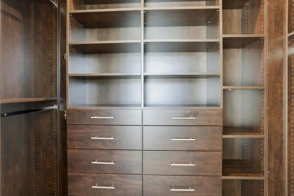 a view of walk in closet with empty racks