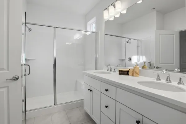 a bathroom with a shower sink vanity and mirror