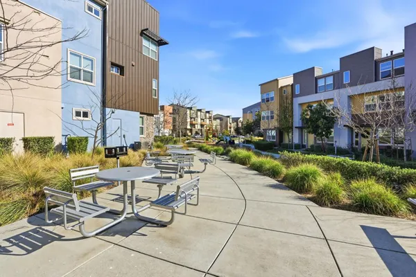 a view of a patio with couches and table and chairs and potted plants