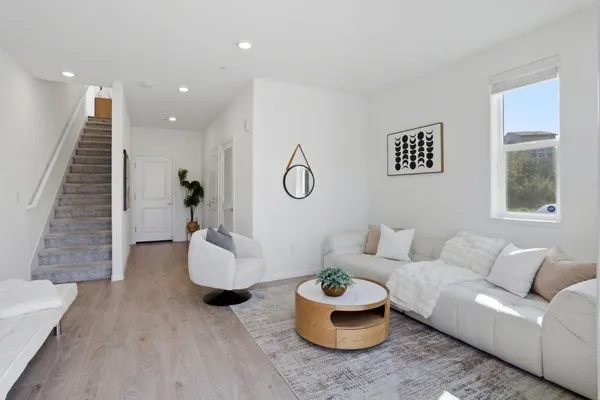 a living room with furniture and a wooden floor