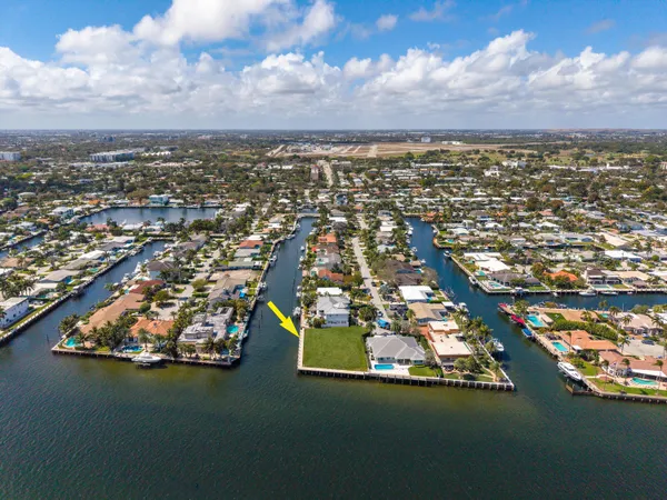 an aerial view of a city with lots of residential buildings ocean and mountain view in back