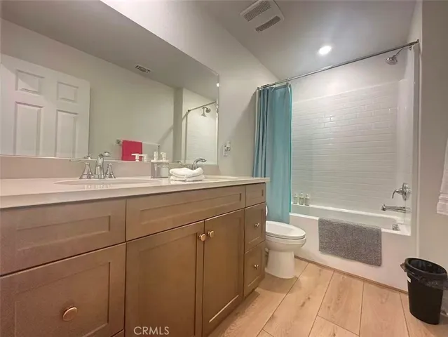a bathroom with a double vanity sink toilet mirror and shower