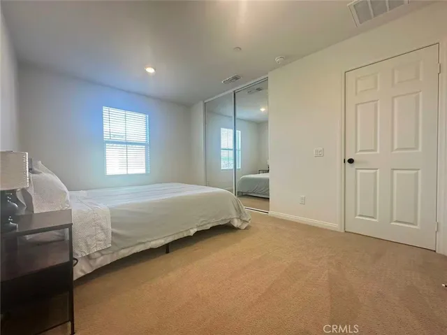 a spacious bedroom with a bed and a window