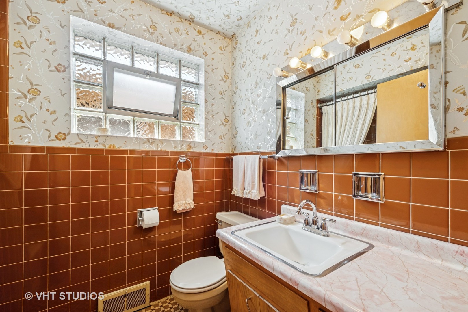 4143 West Devon Avenue Chicago, IL 60646 - Photo 15 of 22 a bathroom with a sink a toilet and mirror