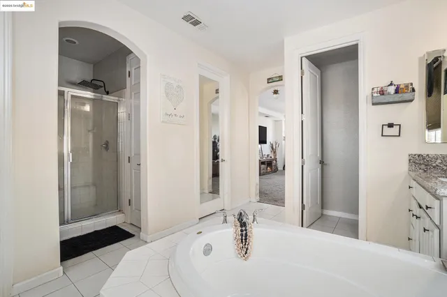 a spacious bathroom with a tub sink and mirror