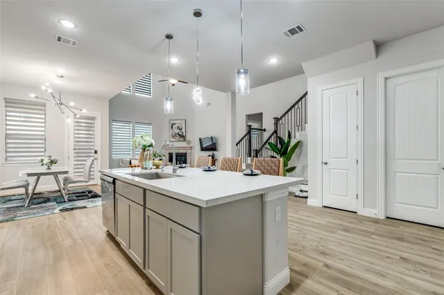 a kitchen with kitchen island a sink and a stove top oven