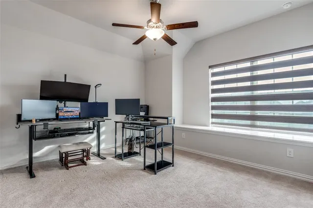 a view of a workspace with furniture and a window