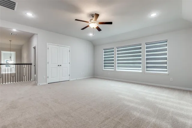 an empty room with windows and fan