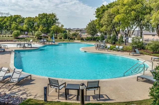 a view of a swimming pool with lawn chairs under an umbrella