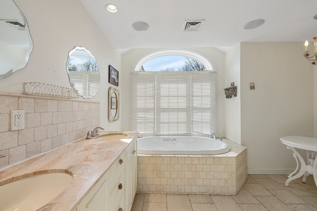 75 Cornell Road Marblehead, MA 01945 - Photo 17 of 26 a bathroom with a tub a double vanity sink and a mirror