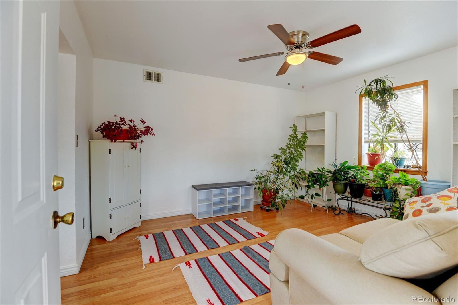 1256 Ulster Street Denver, CO 80220 - Photo 4 of 26 a bedroom with a bed and a chandelier