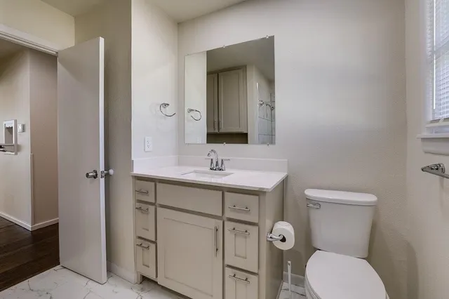 a bathroom with a toilet sink and mirror