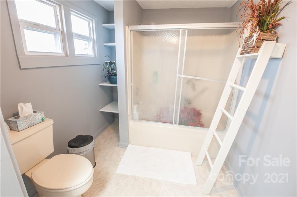 15655 Cool Springs Road Cleveland, NC 27013 - Photo 19 of 26 a white toilet sitting next to a bathroom sink and a tub