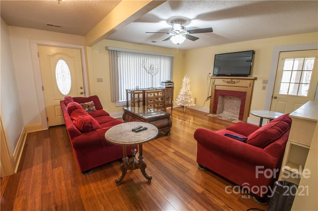 15655 Cool Springs Road Cleveland, NC 27013 - Photo 6 of 26 a living room with furniture a fireplace and a flat screen tv