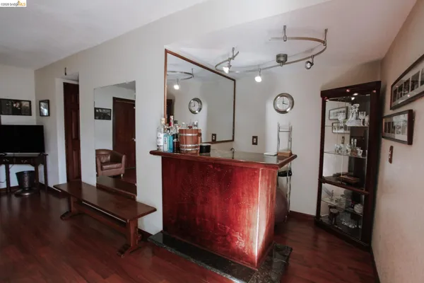 a living room with stainless steel appliances kitchen island granite countertop wooden floor a couch and a view of living room