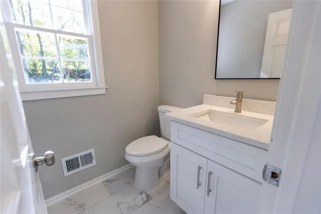 a bathroom with a sink toilet and a mirror