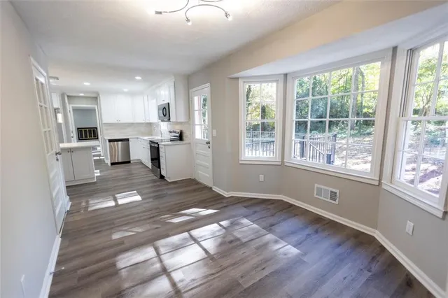 a view of a kitchen with fridge and windows
