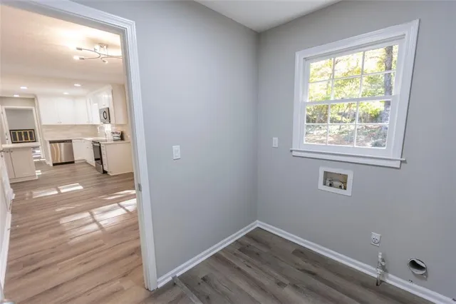 a view of a kitchen with wooden floor and a window