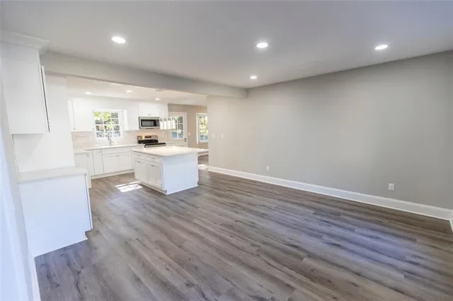 a kitchen with a wooden floor and electronic appliances