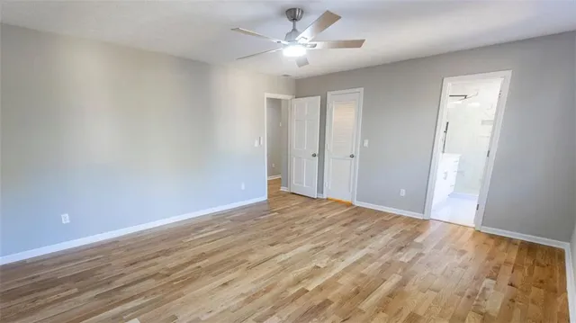 a view of a big room with wooden floor and a ceiling fan