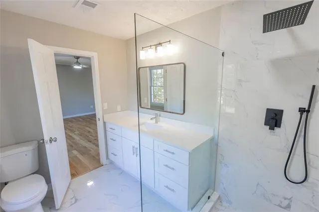 a bathroom with a sink a toilet and shower