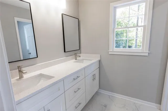 a bathroom with a double vanity sink and mirror with window