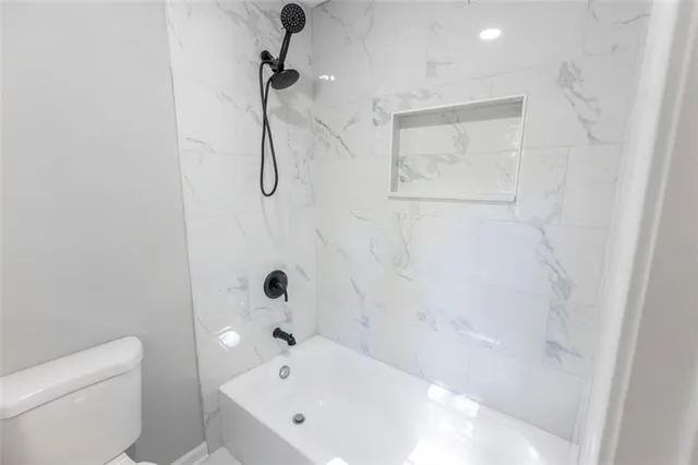 a bathroom with a bath tub with a toilet