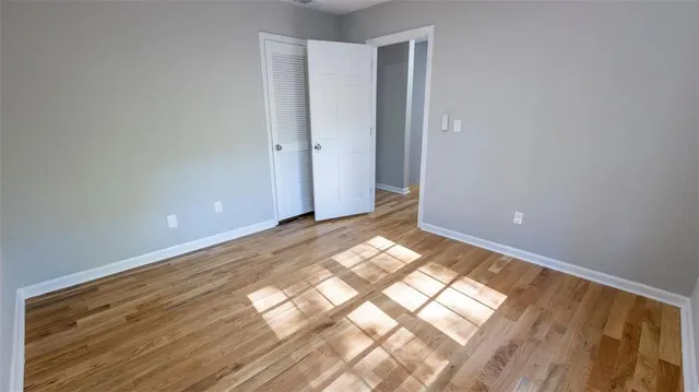 a view of empty room with wooden floor