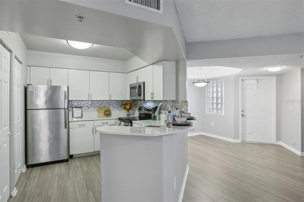 10101 Southwest 14th Street, Unit 3B10108 Pembroke Pines, FL 33025 - Photo 27 of 48 a kitchen with a refrigerator a sink and a stove top oven