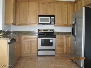 8342 Cardinal Road Fort Myers, FL 33967 - Photo 2 of 7 a kitchen with white cabinets and stainless steel appliances