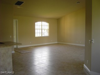 8342 Cardinal Road Fort Myers, FL 33967 - Photo 3 of 7 an empty room with wooden floor and windows