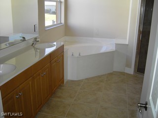 8342 Cardinal Road Fort Myers, FL 33967 - Photo 5 of 7 a bathroom with a sink and a mirror