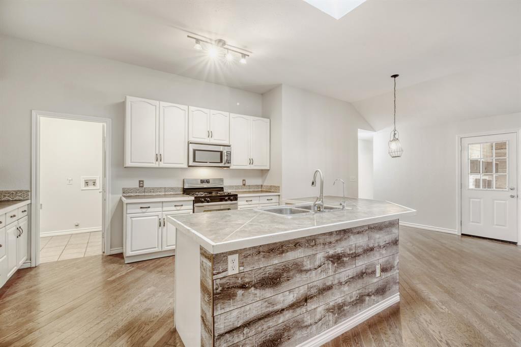 308 Butternut Drive Fate, TX 75087 - Photo 12 of 21 a kitchen with a stove a sink and a refrigerator