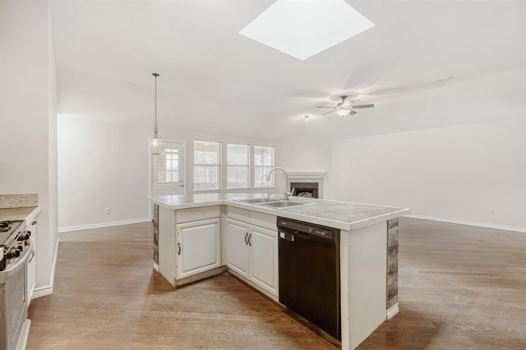 308 Butternut Drive Fate, TX 75087 - Photo 13 of 21 a kitchen with a sink dishwasher a stove and a refrigerator with wooden floor