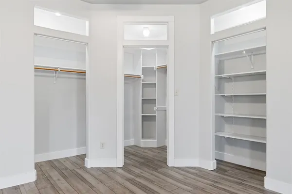 a view of walk in closet with wooden floor