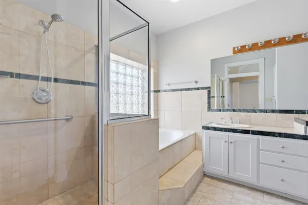 a bathroom with a granite countertop sink a mirror and a shower