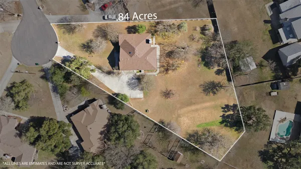 an aerial view of a house with a yard and covered with swimming pool
