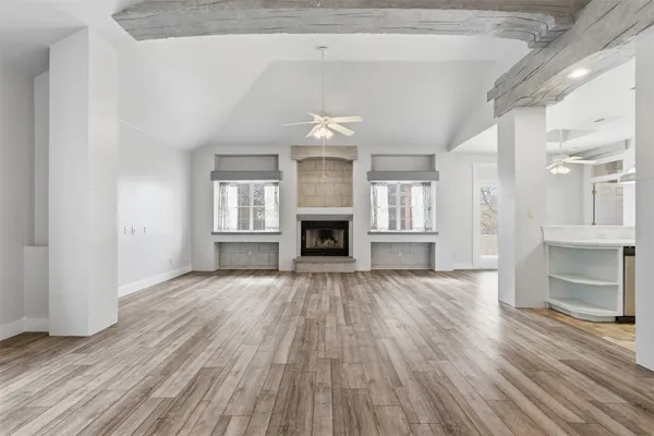 an empty room with wooden floor and fireplace