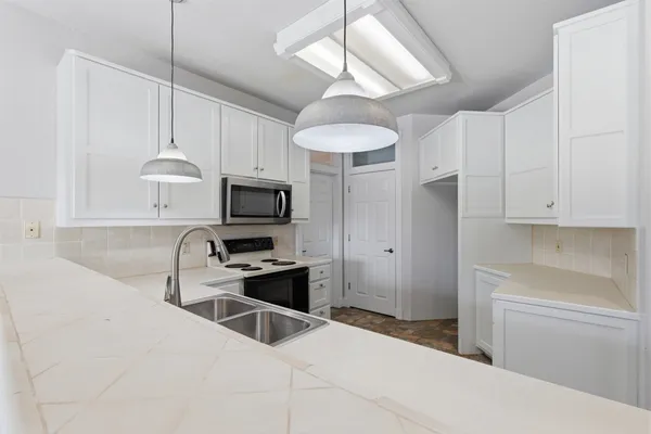 a kitchen with stainless steel appliances granite countertop a sink a stove and a refrigerator