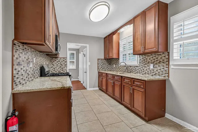 a kitchen with stainless steel appliances granite countertop a stove sink and cabinets
