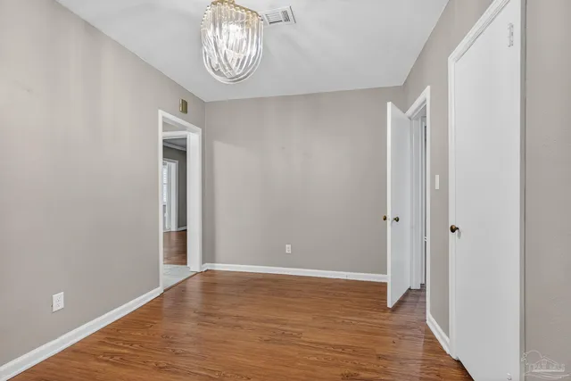 a view of a hallway with wooden floor and closet