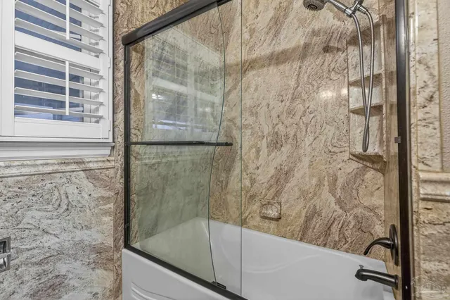 a view of a room with wooden floor chandelier fan and windows