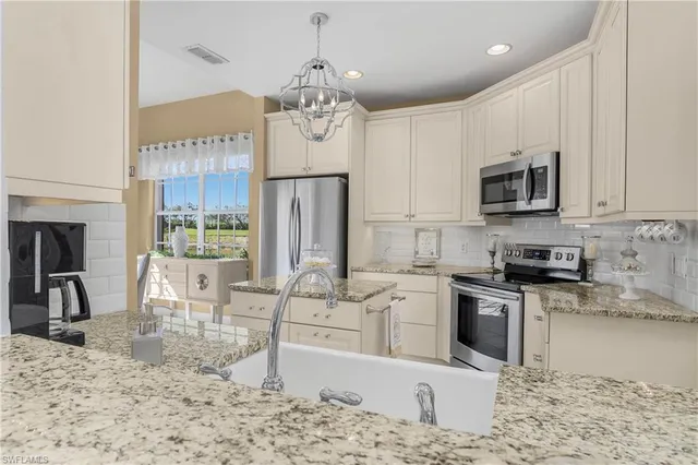 a kitchen with stainless steel appliances kitchen island granite countertop a stove top oven a sink dishwasher a dining table and chairs with wooden floor