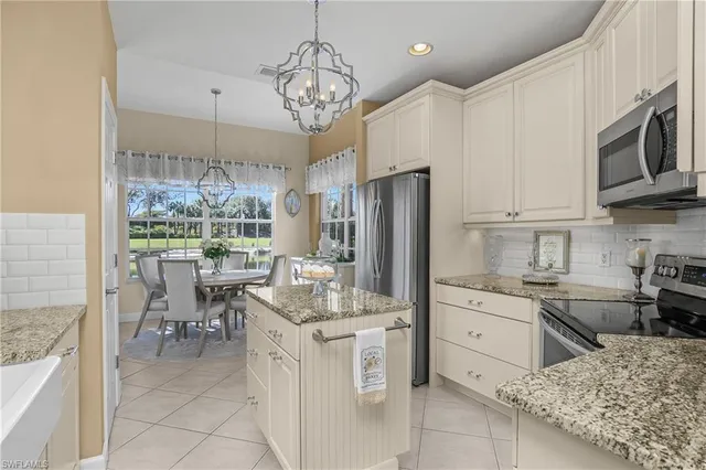a kitchen with stainless steel appliances granite countertop a stove refrigerator and cabinets