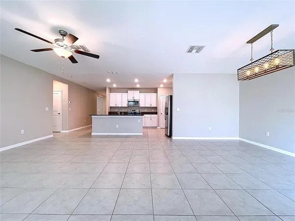 an empty room with windows and ceiling fan