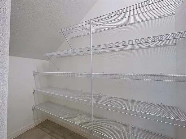 an empty room with wooden floor ceiling fan and windows